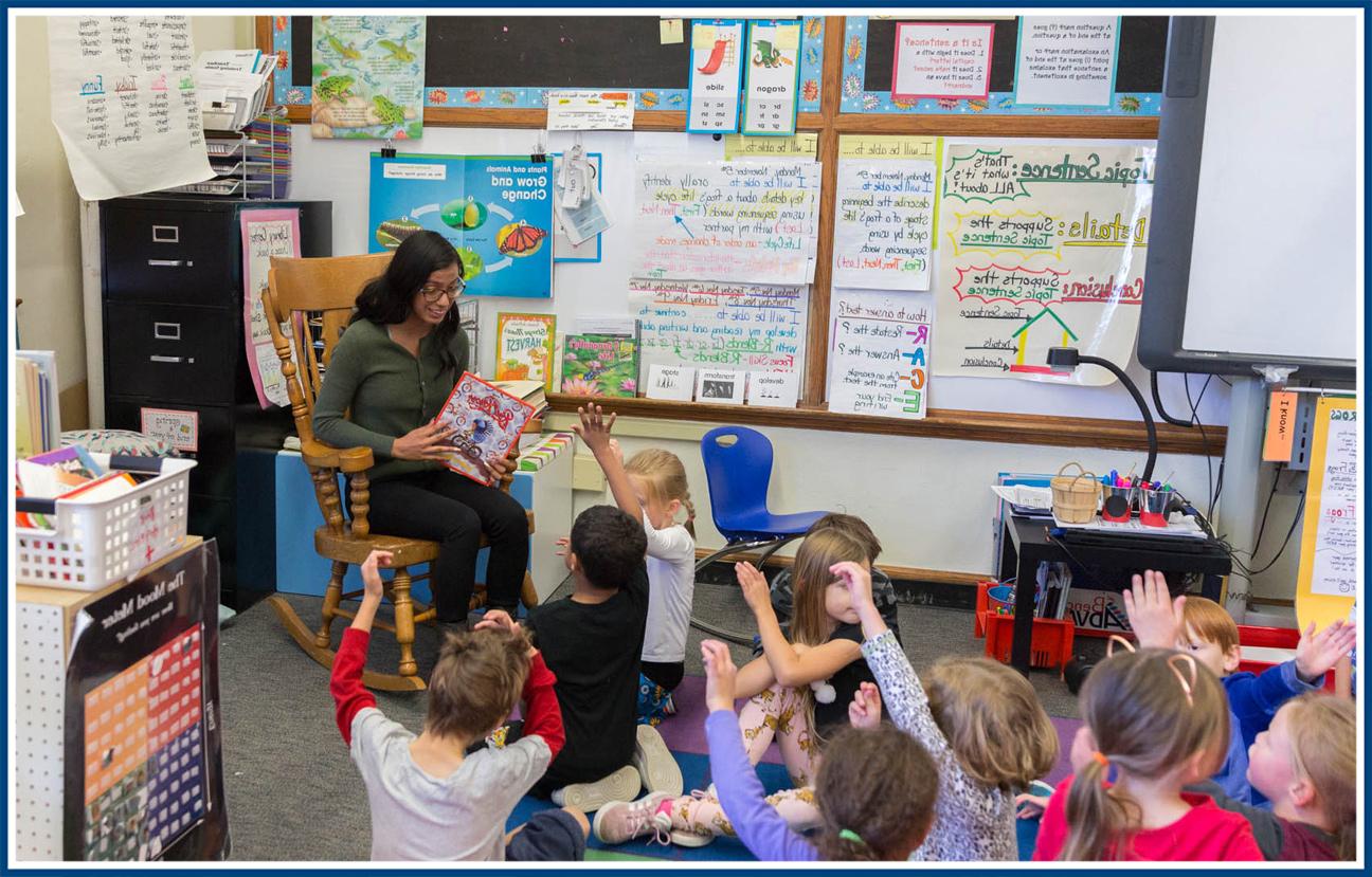 Student teacher reading to a room of elementary school students.